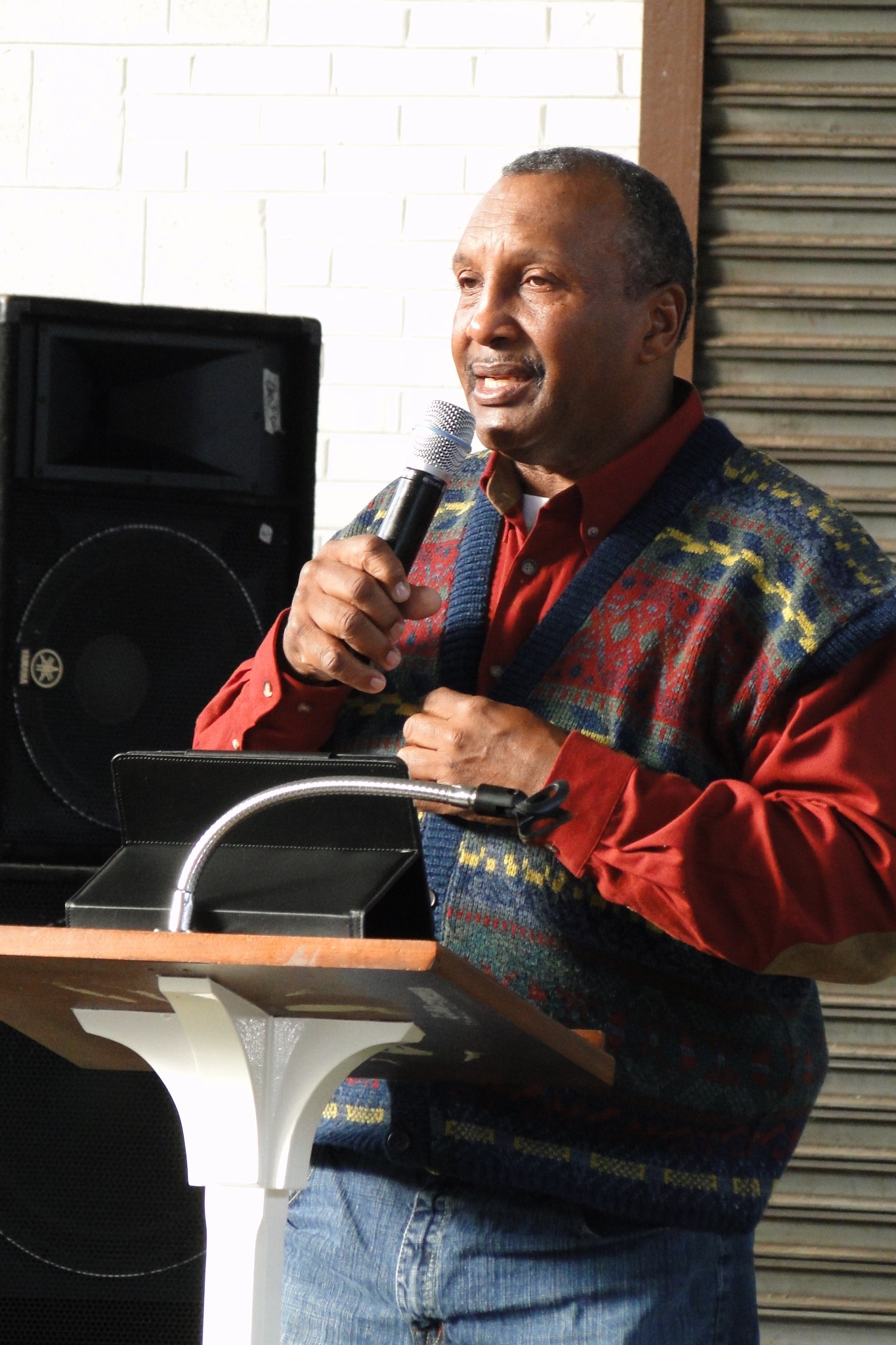 Bill Walden, founder of Walden Sound, speaking at a podium